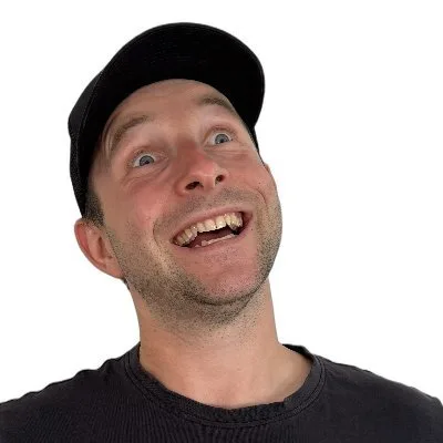Mike in a black cap, grinning at the camera